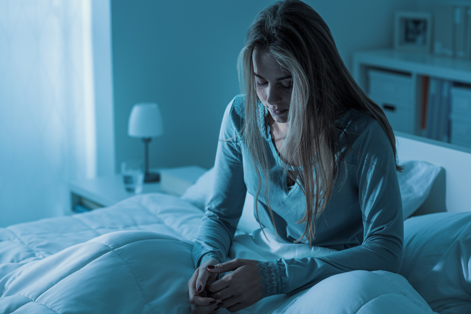 Depressed woman awake in the night, she is exhausted and suffering from insomnia