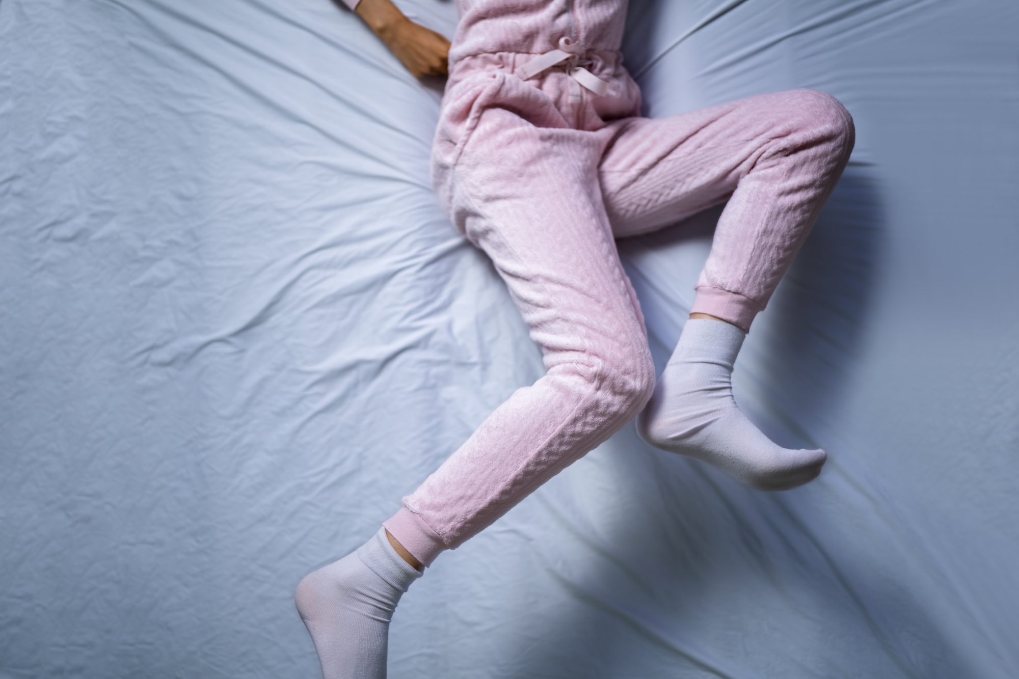 African American Woman With RLS - Restless Legs Syndrome. Sleeping In Bed