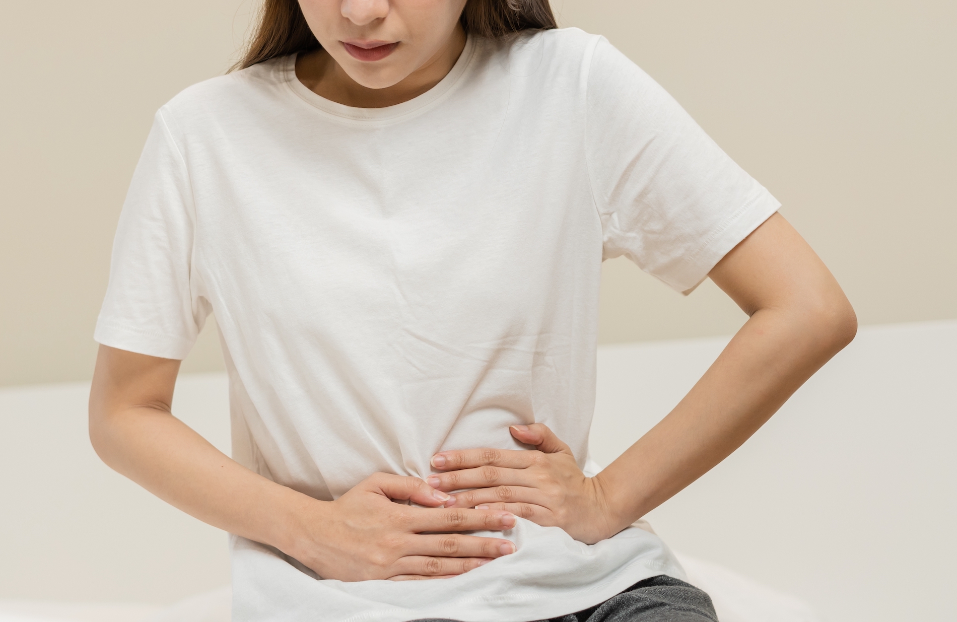 Menstruation, period cycle day of monthly, hurt asian young woman, female hand in stomachache, suffer from PMS premenstrual, belly or abdomen pain on bed at home. Health problem Inflammation in body