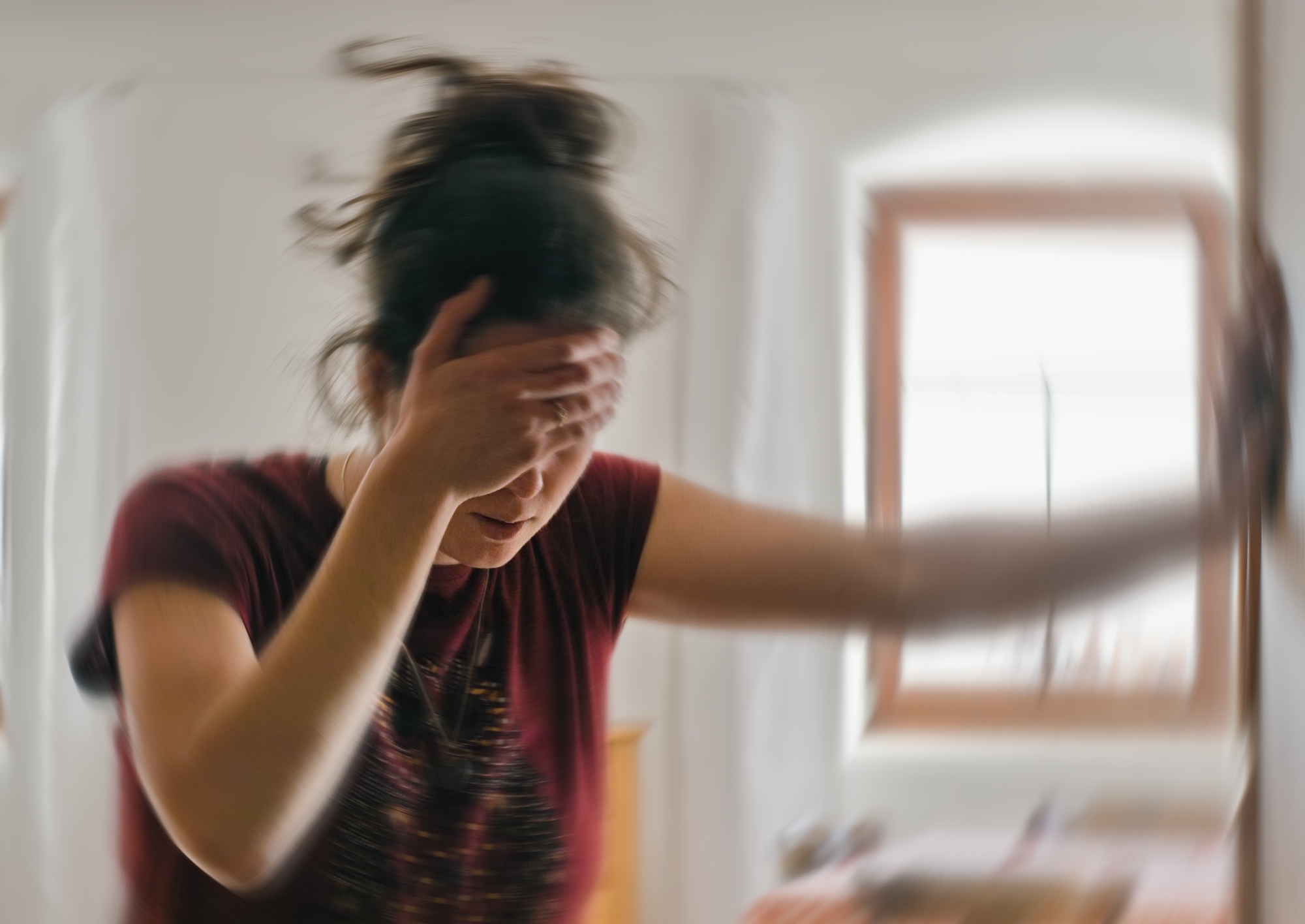 Blured photo of a woman suffering from vertigo or dizziness or other health problem of brain or inner ear.