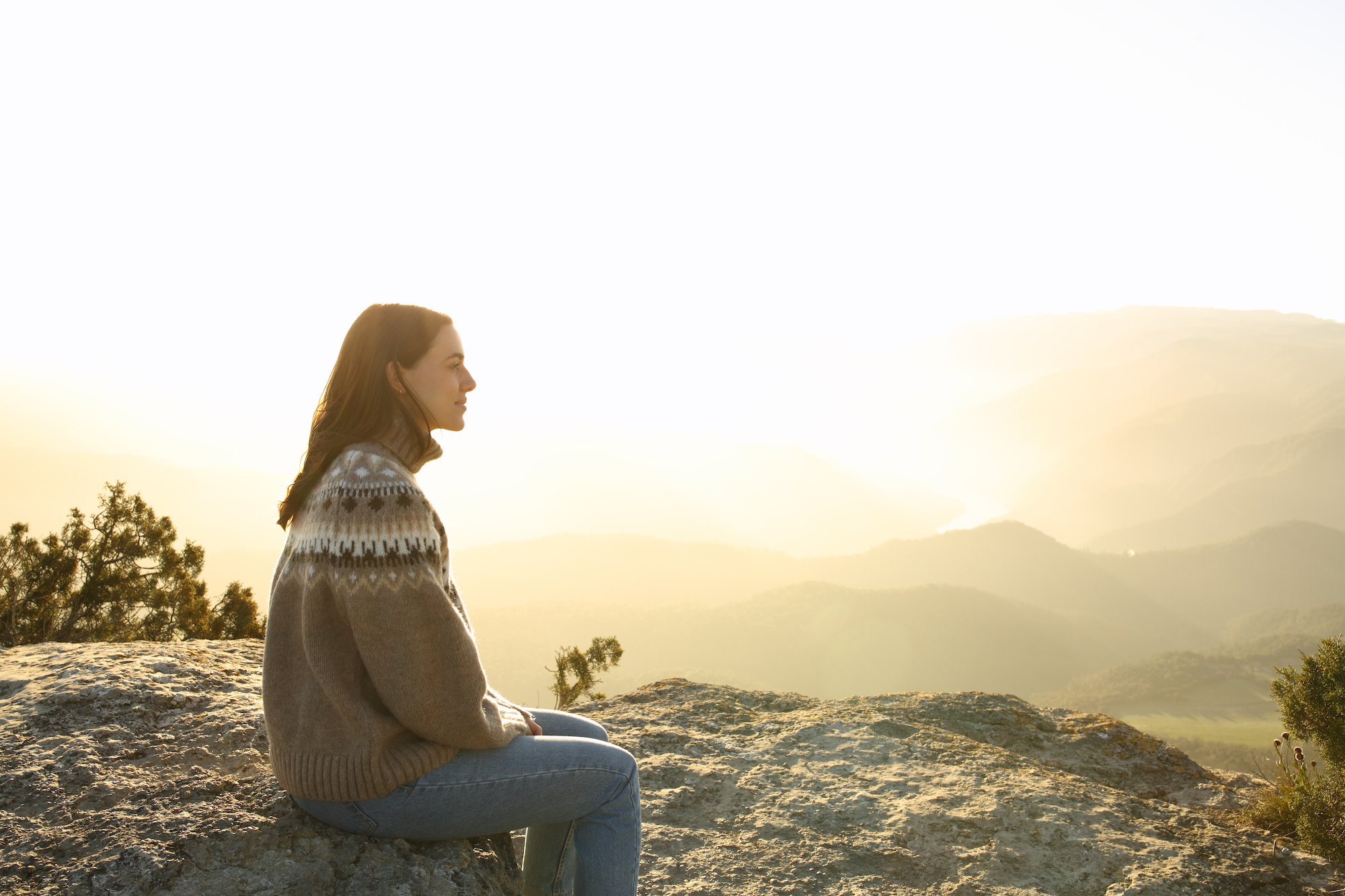 Side view portrait of a casual woman in the top of a cliff contemplating views in winter